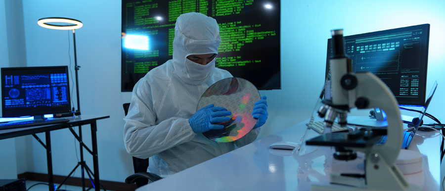 A lab technician holds a semiconductor in a laboratory
