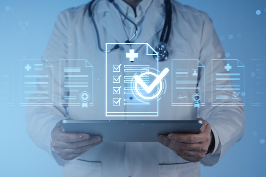 person in lab coat holding a laptop with computer code